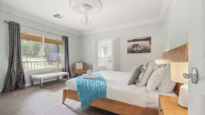 A bedroom with a bed, bench, chandelier, and artwork. - Burton Farmhouse Reconnect with Nature and Family (Wilyabrup)