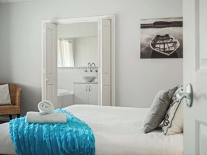 A bedroom with a bed, a bathroom with a sink, a mirror, and a door. - Burton Farmhouse Reconnect with Nature and Family (Wilyabrup)