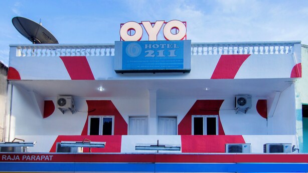 A hotel building with a prominent sign reading 'OYO HOTEL 211' and a satellite dish on the roof. - OYO 2045 Hotel 211 (Parapat)