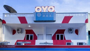 Een hotelschiltje met de naam 'OYO HOTEL 211' en een schotelantenne op het dak.