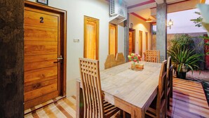 Ein Holztisch mit Stühlen, eine Tür mit der Nummer 2 und ein Deckenventilator.