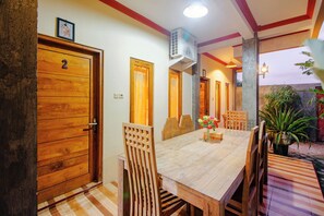 Ein Holzespeisesaal mit Stühlen, einem Deckenventilator und der Zahl '2' auf einer Tür.