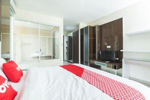 A hotel room with a bed, a TV, a wardrobe, and a bathroom. - OYO 2001 Taman Dayu Villa Golf View (Prigen)