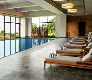 Una piscina cubierta, tumbonas