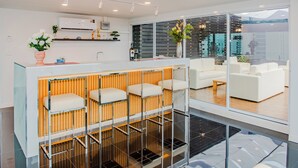 A modern hotel lobby with a bar area, seating, and large windows offering a view. - The Rizin Hotel Phratumnak (Pattaya)