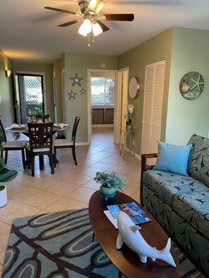 Relax in this inviting living area with a comfortable sofa, dining table for four, and a coffee table.