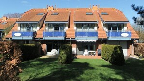 A two-story residential building with a tiled roof, multiple balconies, and a well-maintained lawn. - Papillon Whg. 17/1, Germany (Ostseebad Boltenhagen)