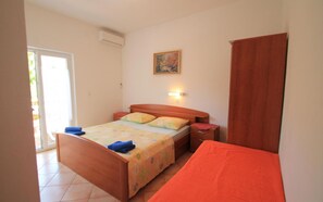 A bedroom with a wooden bed, a nightstand, a bedside table, a window, and a painting on the wall. - The Apartment Daisy is in an excellent location, close to Rab . (Rab)
