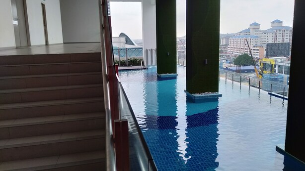 A swimming pool with clear blue water, surrounded by a glass railing. - Summer Studio 2 - One South (Seri Kembangan)