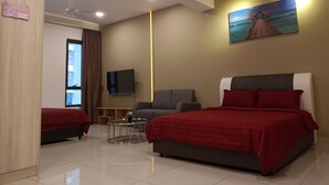 A modern hotel room with a large bed, a smaller bed, a sofa, a TV, and a painting on the wall. - Summer Studio 2 - One South (Seri Kembangan)