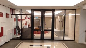 A lobby with a glass door entrance, a reception desk, and a modern interior design. - Summer Studio 2 - One South (Seri Kembangan)