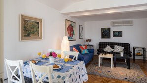 Un comedor con una mesa lista para el desayuno, un sofá y una mesa de centro en una sala de estar.