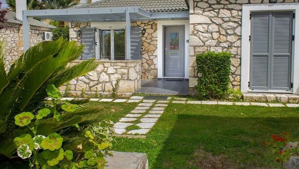 A stone house with a tiled roof, a covered porch, and a well-maintained garden. - Harmony Villa — Stone Retreat in Zakynthos Marine Park, 2 km to Laganas Beach (Mouzaki)