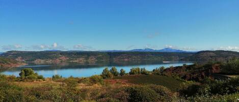 Una vista pintoresca de un lago rodeado de colinas y vegetación.