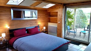 Une chambre à coucher avec un lit, des lampes de chevet, une fenêtre et une vue sur l’extérieur.