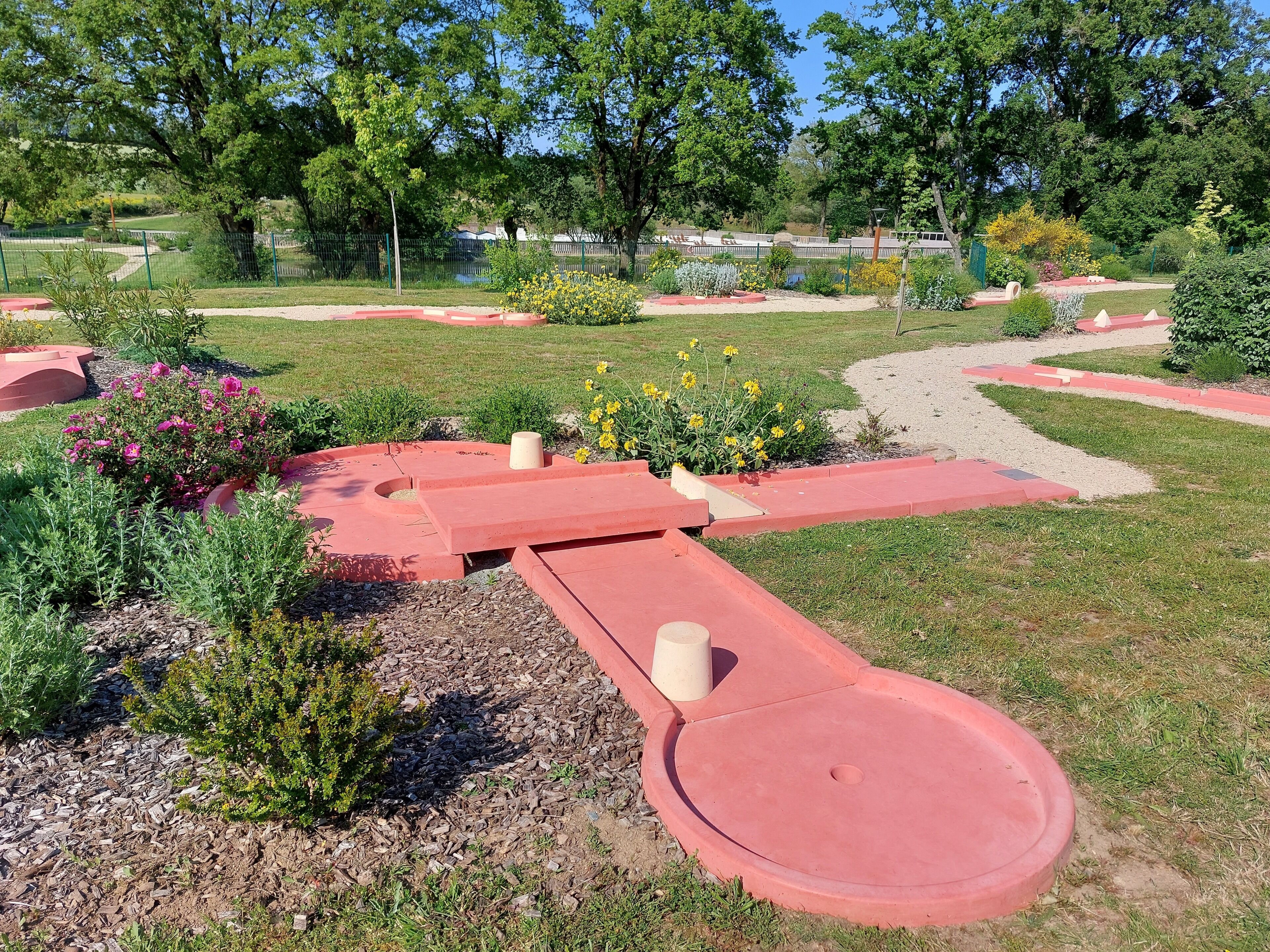 A landscaped garden with pathways, flower beds, and a variety of plants.