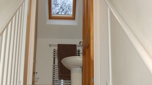 A staircase leading to a bathroom with a window above the sink.