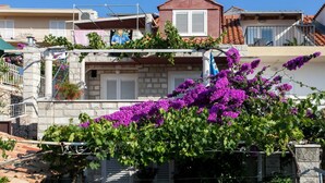 A residential building with a stone facade, white shutters, and a red roof. - Guest House Misita (Dubrovnik)