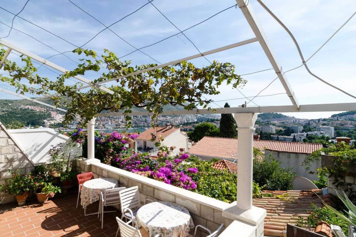 Une terrasse dotée d’une pergola, d’un espace salon extérieur et offrant une vue sur le paysage urbain.