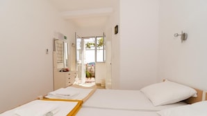 A hotel room with two beds, a bathroom with a shower, and a view of the outdoors. - Guest House Misita (Dubrovnik)