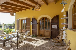 A cozy room with a bed, a rocking chair, and a wooden door with a sign. - Rustic property with 3 bedrooms, 2 bathrooms, pool and barbecue. (Inca)