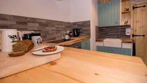 A kitchen with a wooden countertop, a toaster, a kettle, and a sink. - The Cuddly Cow Cosy Barn Studio Campview Farm Stay (Ballyshannon)