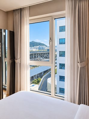 A hotel room with a large window, curtains, and a bed. - Hound Hotel Busan Station (Busan)