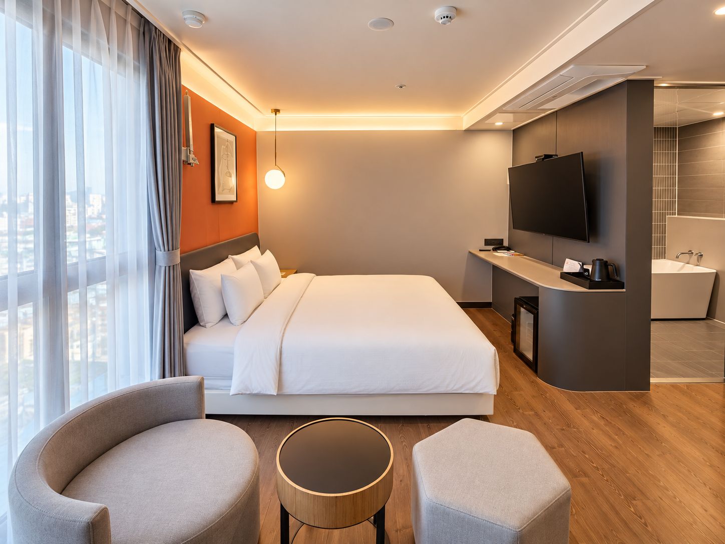 Une chambre d’hôtel moderne équipée d’un grand lit, d’un bureau, d’une télévision et d’une salle de bain.