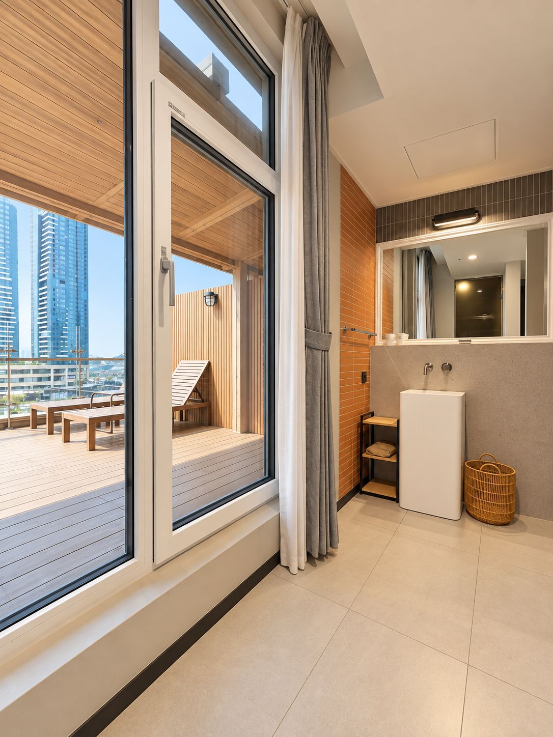 A modern bathroom with a large window, a mirror, a sink, and a shower area.
