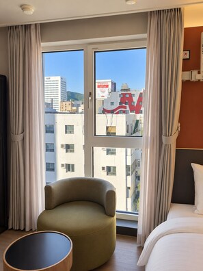 A hotel room with a bed, a round table, a chair, and a window with curtains. - Hound Hotel Busan Station (Busan)