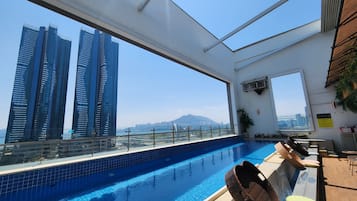 Alberca al aire libre, sombrillas en la alberca y camastros