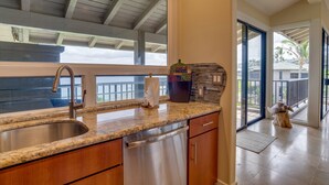 A modern kitchen with a granite countertop, stainless steel sink, and a dishwasher.