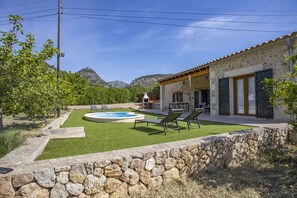 Uma casa de pedra com piscina, área de estar externa e vista para montanhas.