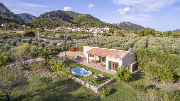 A villa with a swimming pool, outdoor furniture, and a view of the surrounding hills and village. - Beautiful farm with 2 bedrooms, 2 bathrooms, wifi, pool and barbecue (Caimari)