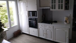 A kitchen with white cabinets, a stove, an oven, a microwave, and a coffee maker. - Character house for up to 6 people (Telgruc-sur-Mer)