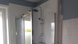 A bathroom with a glass-enclosed shower, a sink with toiletries, and a tiled floor. - Character house for up to 6 people (Telgruc-sur-Mer)