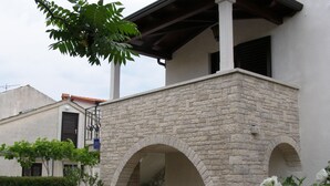 Un edificio con arcos de piedra y un jardín con plantas y flores en macetas.