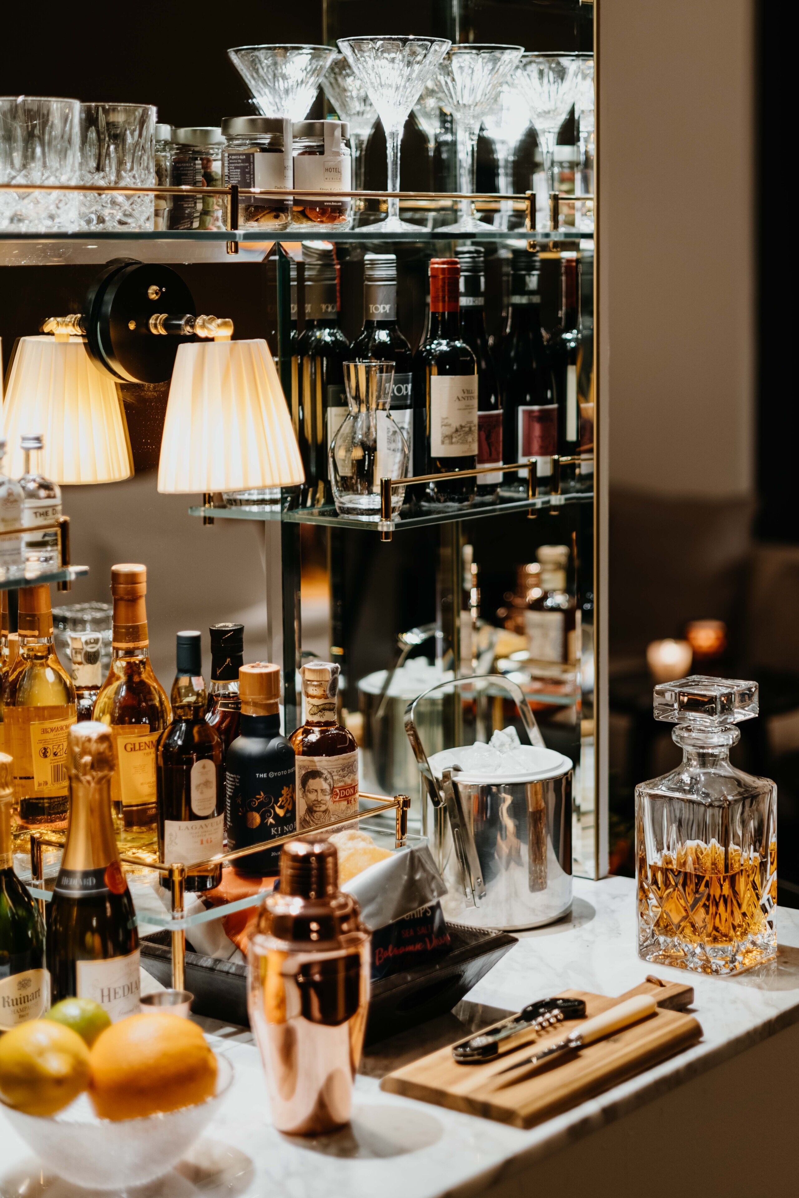 Zona de bar con diversas botellas de licor, vasos y utensilios.