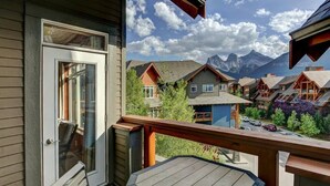 Ein Balkon mit Blick auf Berghäuser und eine Holzdielen-Terrasse.