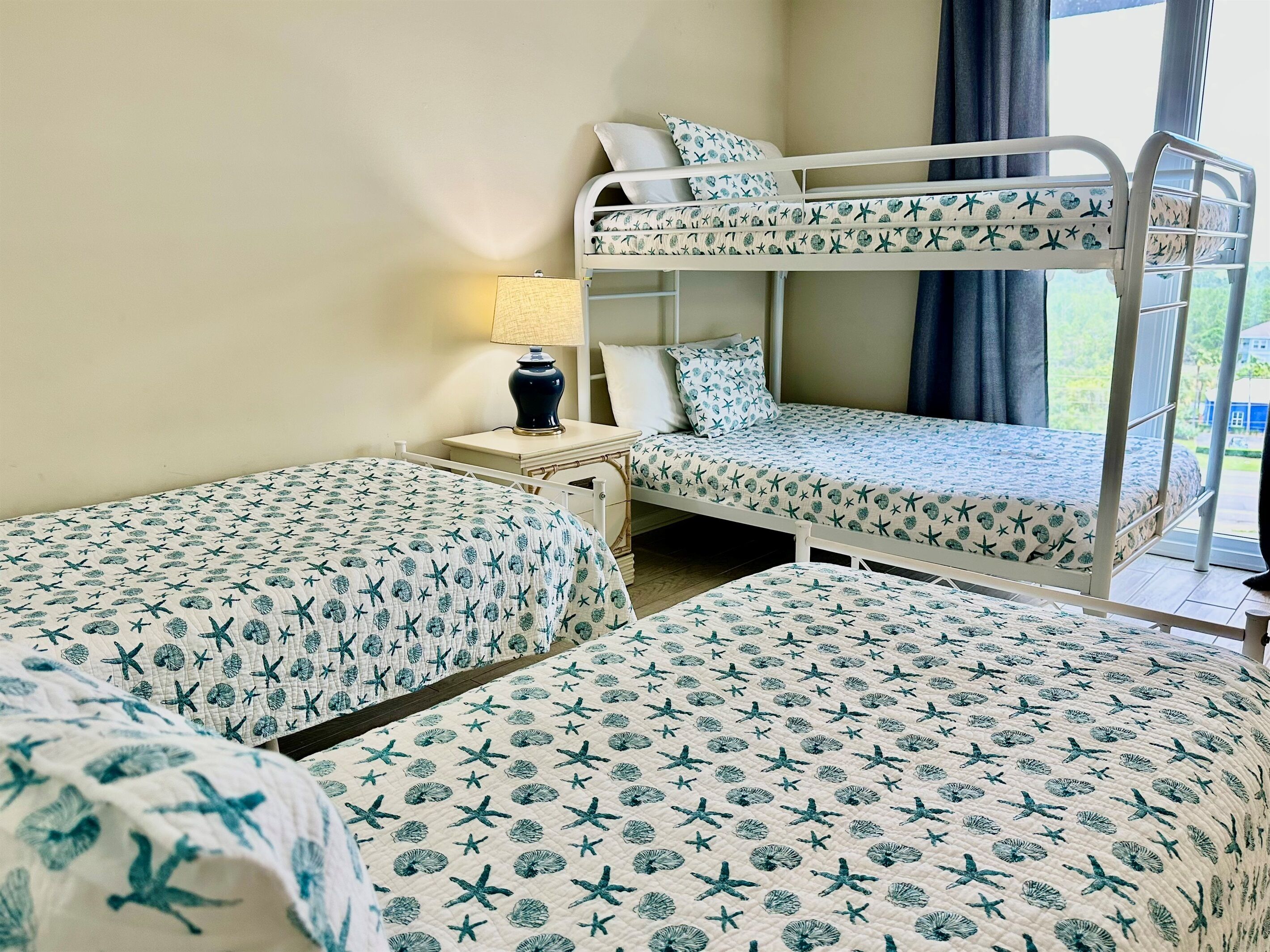 Ein Zimmer mit Etagenbetten und zwei Einzelbetten, jeweils mit passender Bettwäsche.