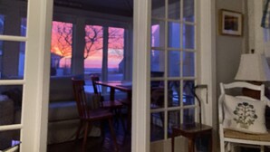 A room with a dining area, a chair, a table, and a lamp. - OCEAN VIEWS & A/C in cozy condo w/upscale finishes!- STEPS TO PRIVATE BEACH (Mashpee)