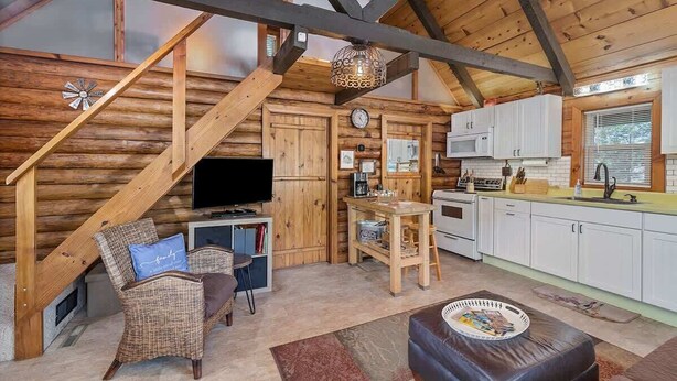 Un intérieur chaleureux de chalet en bois, comprenant un espace de vie, une cuisine et un coin repas.