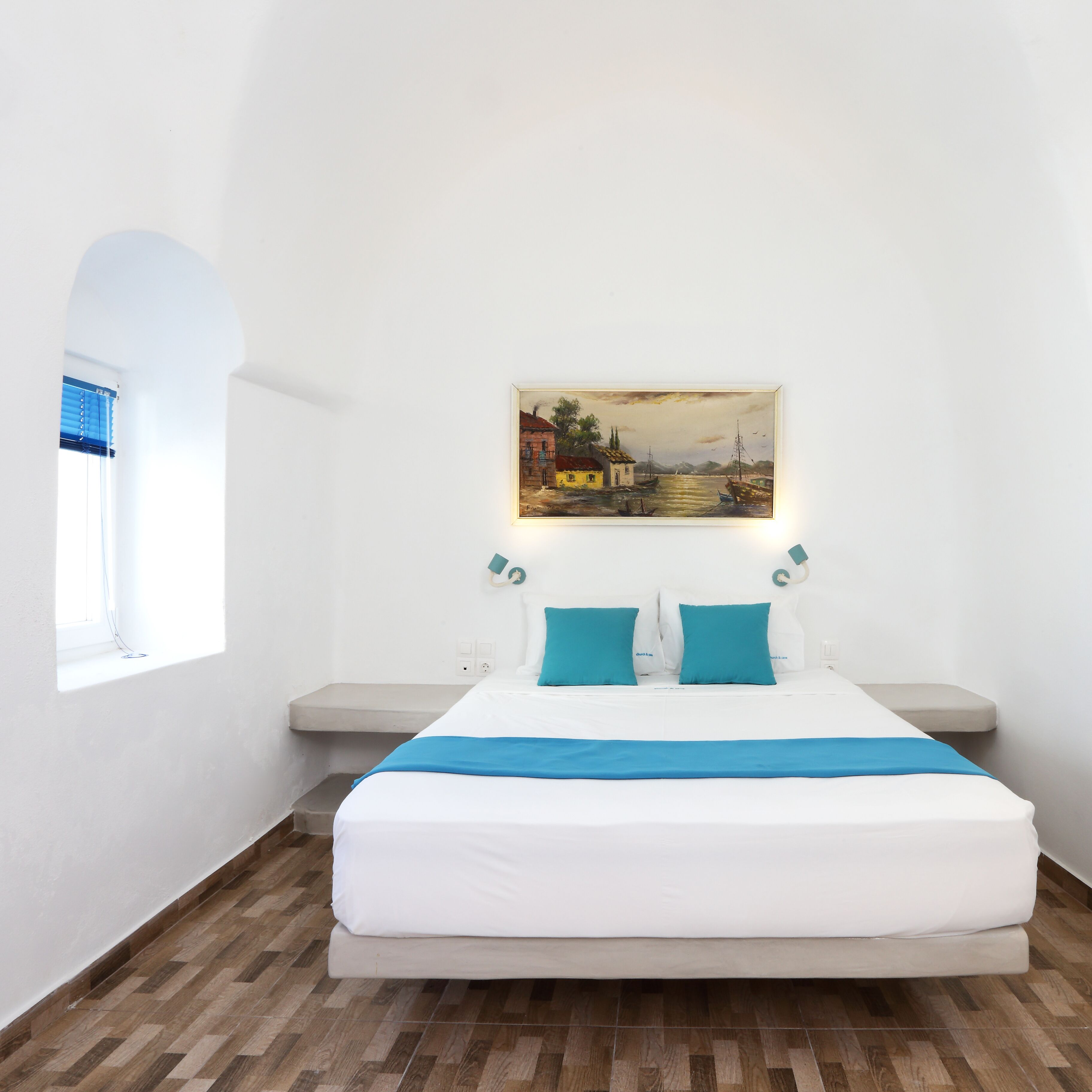 Ein Schlafzimmer mit Bett, Gemälde und Fenster mit Jalousien.
