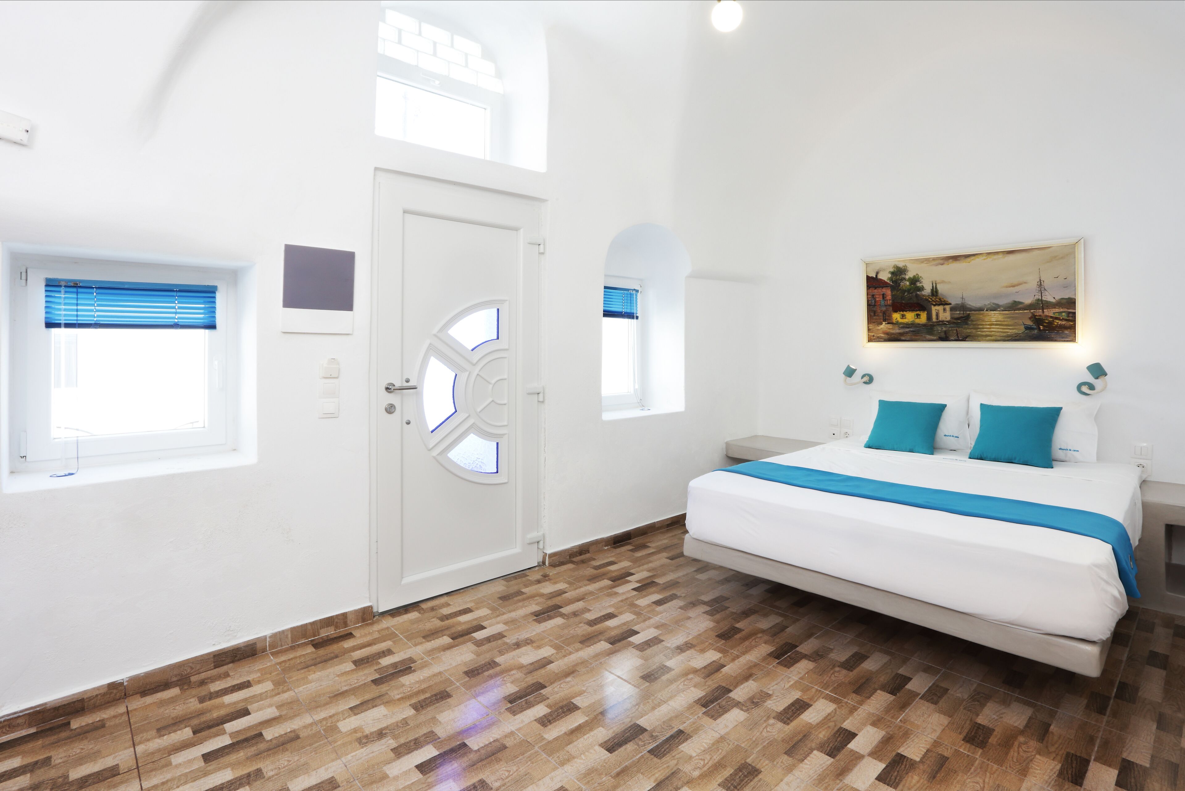 Um quarto com uma cama grande, uma porta branca e um quadro na parede.