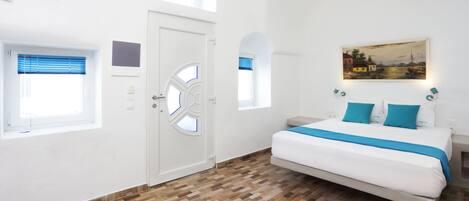 Un dormitorio con una cama grande, una puerta blanca y un cuadro en la pared.