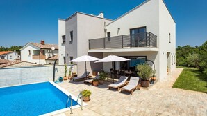 A modern two-story house with a swimming pool, outdoor seating, and a garden. - Modern Villa Leonardo with an outdoor pool (Porec)
