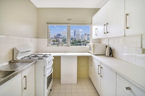 Enjoy cooking with a gas stove, oven, and microwave in this well-lit kitchen with a city view.