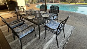 An outdoor dining area with a pool view.