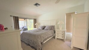 A bedroom with a bed, nightstands, a dresser, and a wardrobe.