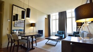 A modern hotel room with a dining area, a sofa, a coffee table, and a lamp. - Dom Luis I Prestige Flat 17 (Lisboa)